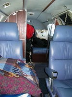 Tons of bags stuffed to overflowing in the aft baggage area.  Note the blankets in the foreground to help keep passengers warm in cruise.  