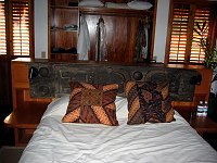 Doug's bedroom at Turtle Inn.  Note the carved wood on the headboard, with spot reading lights.  <br>
